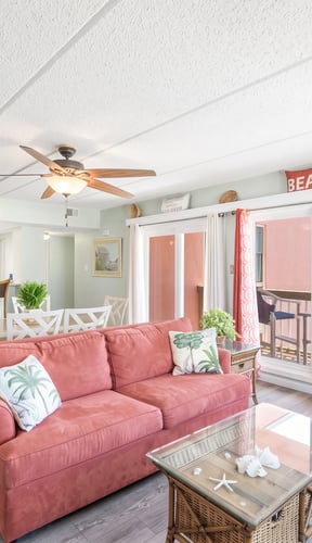Three-bedroom condo open living and dining area with Gulf view through balcony doors