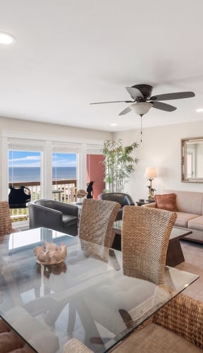 Two-bedroom condo living room with wicker dining chairs and Gulf of Mexico view